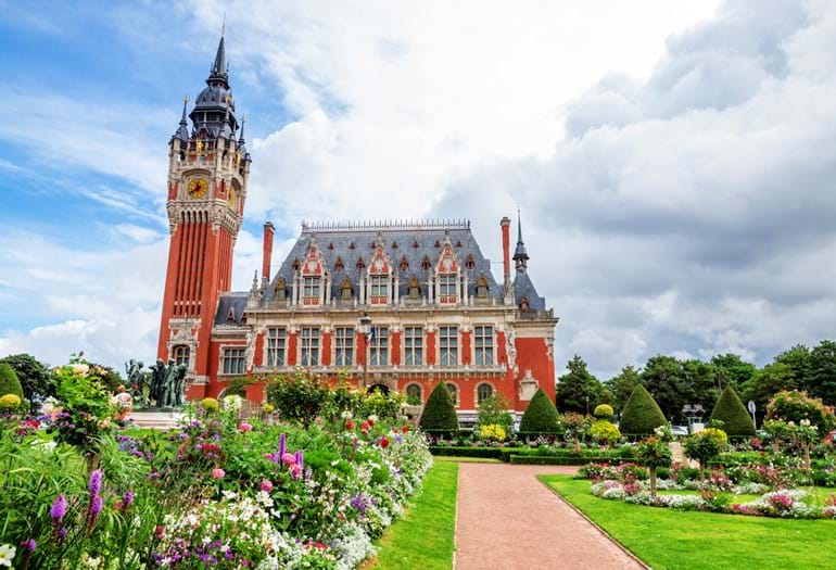 View of Calais’ Hôtel de Ville set in landscaped gardens with flowers